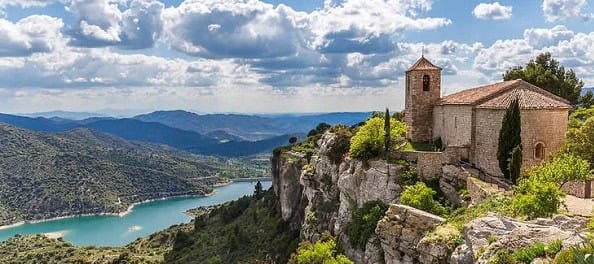 iglesia montaña pantano cielo azul arboles verdes nubes