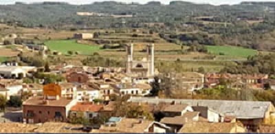 Vista del pueblo Olost en Barcelona desde el cerro, casas, iglesia con dois torres, cielo azul vegataciones