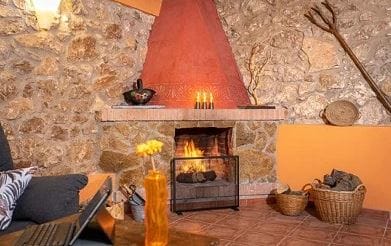 casa rural rustica sala chimenea paredes piedra asientos